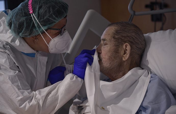 Một nhân viên y tế chăm sóc Manuel Padiel, phải, người đang hồi phục sau COVID-19, tại khoa ICU của Bệnh viện San Juan de Dios, ở Pamplona, miền bắc Tây Ban Nha, Thứ Hai, ngày 8 tháng 2 năm 2021. (Nguồn: AP Photo / Alvaro Barrientos)