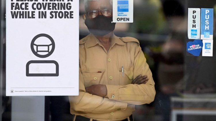 Một nhân viên bảo vệ đeo mặt nạ bên trong một cửa hàng ở New Delhi, Ấn Độ (Ảnh: AFP)
