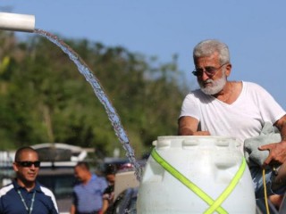 Một người đàn ông đổ đầy nước suối vào thùng phuy nhựa từ một ngọn núi ở Utuado, Puerto Rico, ngày 21 tháng 10 năm 2019. Tiếp cận với nước ngọt, sạch là quyền cơ bản của con người cần phải được bảo vệ, đặc biệt là ở những vùng nghèo, nơi đàn ông, phụ nữ và trẻ em đang phải gánh chịu những tác động chết người của biến đổi khí hậu (Ảnh: Bob Roller / CNS)