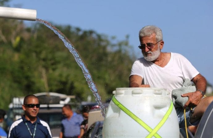 Một người đàn ông đổ đầy nước suối vào thùng phuy nhựa từ một ngọn núi ở Utuado, Puerto Rico, ngày 21 tháng 10 năm 2019. Tiếp cận với nước ngọt, sạch là quyền cơ bản của con người cần phải được bảo vệ, đặc biệt là ở những vùng nghèo, nơi đàn ông, phụ nữ và trẻ em đang phải gánh chịu những tác động chết người của biến đổi khí hậu (Ảnh: Bob Roller / CNS)