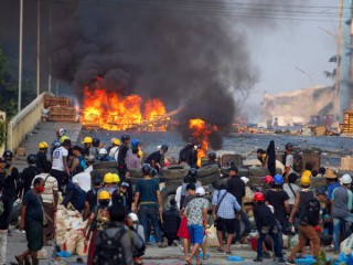 Những người biểu tình chống đảo chính đứng ở một chướng ngại vật khi họ đụng độ với lực lượng an ninh trên Cầu Bayint Naung ở Yangon, Myanmar, ngày 16 tháng 3 năm 2021 (Nguồn: CNS photo / Reuters)