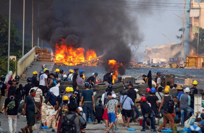 Những người biểu tình chống đảo chính đứng ở một chướng ngại vật khi họ đụng độ với lực lượng an ninh trên Cầu Bayint Naung ở Yangon, Myanmar, ngày 16 tháng 3 năm 2021 (Nguồn: CNS photo / Reuters)