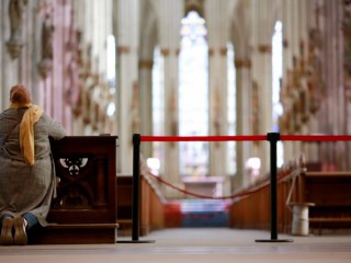 Một phụ nữ cầu nguyện bên cạnh hàng rào bên trong Nhà thờ Cologne ở Đức vào ngày 15 tháng 3 năm 2020, trong đại dịch COVID-19. Các giám mục Công giáo nói rằng những người theo đạo Thiên chúa ở châu Âu không bị đàn áp, nhưng một số chính phủ đã làm suy giảm tự do tôn giáo trong đại dịch. (Nguồn: Thilo Schmuelgen / Reuters qua CNS)