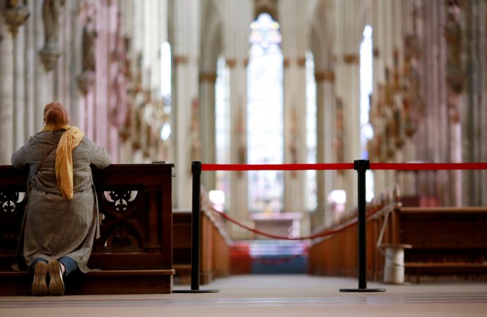 Một phụ nữ cầu nguyện bên cạnh hàng rào bên trong Nhà thờ Cologne ở Đức vào ngày 15 tháng 3 năm 2020, trong đại dịch COVID-19. Các giám mục Công giáo nói rằng những người theo đạo Thiên chúa ở châu Âu không bị đàn áp, nhưng một số chính phủ đã làm suy giảm tự do tôn giáo trong đại dịch. (Nguồn: Thilo Schmuelgen / Reuters qua CNS)