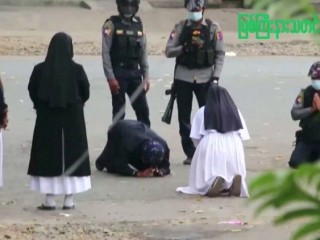Nữ tu Myanmar Ann Rose Nu Tawng quỳ gối trước các sĩ quan cảnh sát.