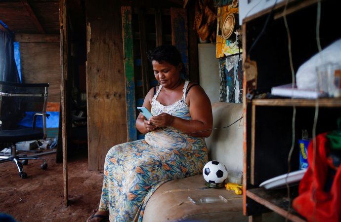 Tatiana Araujo de Sirqueira, 33 tuổi, sử dụng điện thoại di động trong nhà được thiết lập trên khu đất gần Cung điện Planalto trong đại dịch coronavirus ở Brasília, Brazil, ngày 3 tháng 3 năm 2021. Trong một thông điệp gửi tới những người tham gia Nhóm Ngân hàng Thế giới và Quỹ Tiền tệ Quốc tế 2021 Đức Thánh Cha Phanxicô cho biết các nước nghèo khó có thể phục hồi sau cuộc khủng hoảng tài chính hiện nay nếu thế giới quay trở lại mô hình kinh tế trong đó một thiểu số người dân sở hữu một nửa của cải thế giới (Ảnh: Adriano Machado / Reuters)