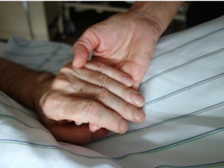 Y tá nắm tay bệnh nhân. (ảnh: Patrick Thomas / Shutterstock)