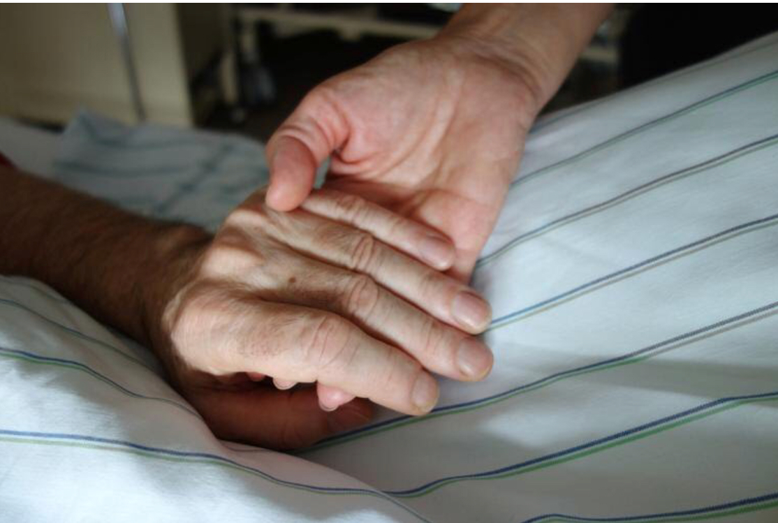 Y tá nắm tay bệnh nhân. (ảnh: Patrick Thomas / Shutterstock)