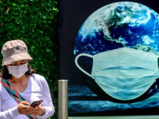 Áp phích Ngày Trái đất mô tả một chiếc khẩu trang ở Bangkok, Thái Lan, trong bối cảnh gia tăng các trường hợp Covid-19 (Ảnh: AFP)