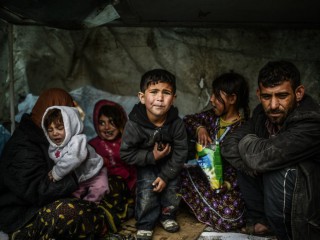 Một gia đình người Syria tị nạn từ Aleppo ở dưới một mái che trong một ngày mưa vào ngày 8 tháng 3 năm 2014 tại Uskudar, Istanbul. Hình ảnh Bulent Kilic — AFP / Getty