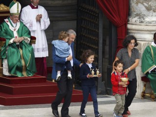 Đức Thánh Cha Phanxicô nhận lễ vật từ một gia đình mang các món quà lên bàn thờ trong thánh lễ dành cho các giáo lý viên tại Quảng trường Thánh Peter ở Vatican vào ngày 29 tháng 9 năm 2013, ảnh tập tin. (Nguồn: Paul Haring / CNS)