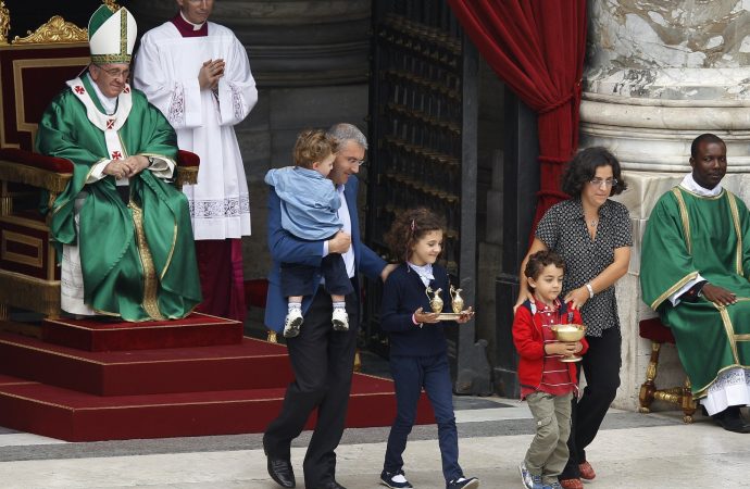 Đức Thánh Cha Phanxicô nhận lễ vật từ một gia đình mang các món quà lên bàn thờ trong thánh lễ dành cho các giáo lý viên tại Quảng trường Thánh Peter ở Vatican vào ngày 29 tháng 9 năm 2013, ảnh tập tin. (Nguồn: Paul Haring / CNS)