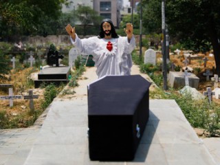 Một bức tượng của Chúa Kitô được đặt trên quan tài của một người đã chết sau khi ký hợp đồng COVID-19 trước khi chôn cất tại một nghĩa địa ở New Delhi ngày 29 tháng 4 năm 2021 (Ảnh: Adnan Abidi / Reuters qua CNS)