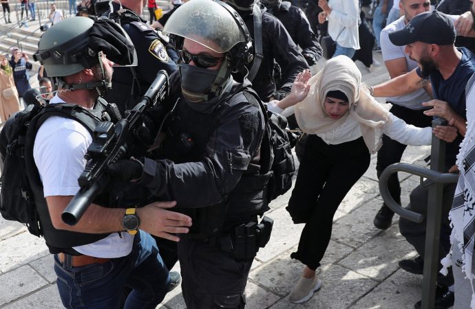 Một phụ nữ Palestine chạy gần các thành viên lực lượng an ninh Israel trong một cuộc biểu tình bạo lực trong bối cảnh căng thẳng giữa Israel và Palestine ngay bên ngoài Thành phố Cổ của Jerusalem ngày 10 tháng 5 năm 2021. Người Palestine đã phản đối việc một số gia đình Palestine có thể bị đuổi khỏi nhà trên đất mà những người định cư Do Thái ở Đông Jerusalem tuyên bố . (Tín dụng: Ronen Zvulun / Reuters qua CNS)