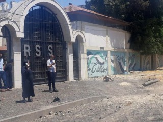 Chị Nabila Saleh, hiệu trưởng trường Rosary Sisters ở Gaza, đứng cùng những người khác tại con đường bên ngoài ngôi trường bị hư hại do vụ ném bom của Israel vào ngày 12 tháng 5 năm 2021. (Nguồn: CNS photo / lịch sự Holy Family Catholic Parish, Gaza)