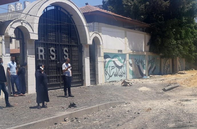 Chị Nabila Saleh, hiệu trưởng trường Rosary Sisters ở Gaza, đứng cùng những người khác tại con đường bên ngoài ngôi trường bị hư hại do vụ ném bom của Israel vào ngày 12 tháng 5 năm 2021. (Nguồn: CNS photo / lịch sự Holy Family Catholic Parish, Gaza)