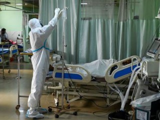 Một nhân viên y tế mặc bộ đồ bảo hộ cá nhân (PPE) chăm sóc một bệnh nhân coronavirus COVID-19 bên trong Đơn vị Chăm sóc Đặc biệt của bệnh viện Đại học Teerthanker Mahaveer ở Moradabad vào ngày 5 tháng 5. (ảnh: PRAKASH SINGH / AFP qua Getty Images)