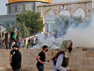 Người biểu tình Palestine tranh cử để được che chắn khỏi hơi cay gần Nhà thờ Hồi giáo al-Aqsa (Ảnh: AFP)