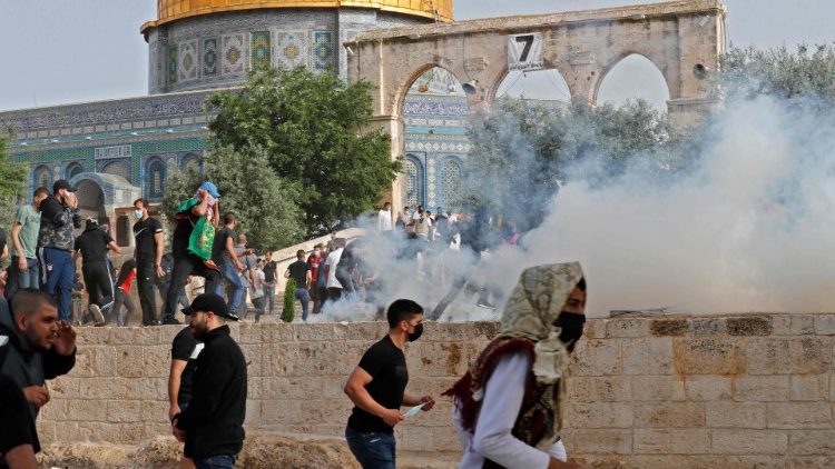 Người biểu tình Palestine tranh cử để được che chắn khỏi hơi cay gần Nhà thờ Hồi giáo al-Aqsa (Ảnh: AFP)