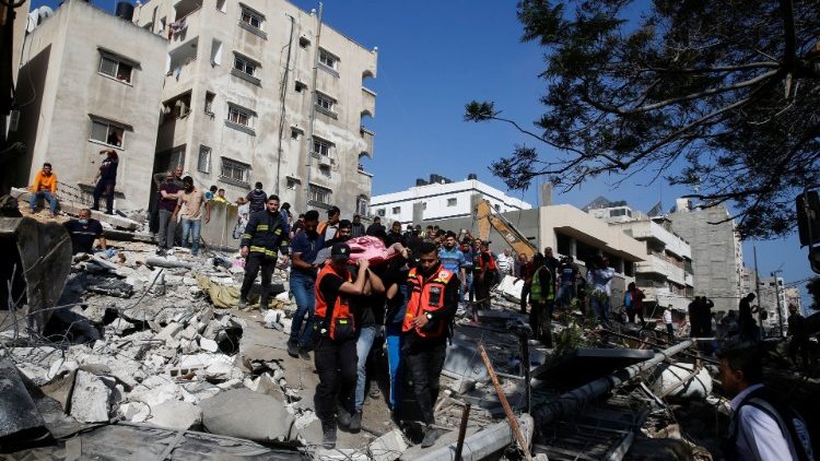 Nhân viên cứu hộ hỗ trợ các nạn nhân giữa đống đổ nát do cuộc không kích của Israel vào thành phố Gaza