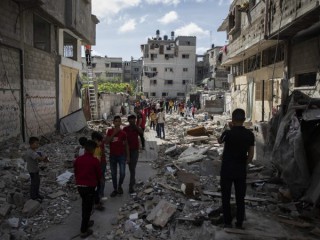 Người Palestine đi bộ giữa đống đổ nát của một ngôi nhà bị các cuộc không kích của Israel vào sáng sớm, ở thành phố Gaza, Thứ Hai, ngày 17 tháng 5 năm 2021. (Nguồn: Khalil Hamra / AP)