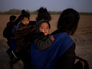 Những người di cư từ Guatemala bế con của họ ở Penitas, Texas, ngày 17 tháng 3 năm 2021, sau khi băng qua Rio Grande. (Tín dụng: Adrees Latif / Reuters, qua CNS)