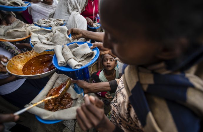Trong bức ảnh được chụp vào Chúa nhật, ngày 9 tháng 5 năm 2021, một cậu bé đang ngóng chờ đợi tới lượt khi những người dânTigrayan bị di tản xếp hàng để nhận thức ăn do cư dân địa phương quyên góp tại một trung tâm tiếp nhận dành cho những người bị di tản ở Mekele, thuộc vùng Tigray, miền bắc Ethiopia (Ảnh: Ben Curtis / AP)