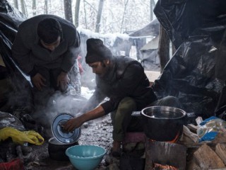 Những người di cư từ Bangladesh chuẩn bị thức ăn tại một trại tạm ở Bosnia (Ảnh: REUTERS)