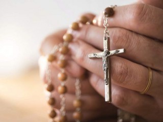 usa--new-jersey--woman-praying-with-rosary-beads-in-hands-580816943-5a9736123418c600367ebf0a