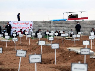Những người đàn ông ở Kojo, Iraq, tụ tập vào ngày 6 tháng 2 năm 2021, gần các ngôi mộ của những người dân tộc thiểu số Yazidi đã bị giết bởi các chiến binh Nhà nước Hồi giáo. Đức Tổng Giám mục Công giáo Chaldean Bashar Warda của Irbil, Iraq, vào ngày 14 tháng 7 năm 2021, phát biểu tại Hội nghị Thượng đỉnh về Tự do Tôn giáo Quốc tế ở Washington rằng ngoài nhu cầu cơ sở hạ tầng của Iraq, điều cần được xây dựng lại là phẩm giá của những người phải chịu đựng dưới chế độ Nhà nước Hồi giáo. (Nguồn: CNS photo / Thaier al-Sudani, Reuters)