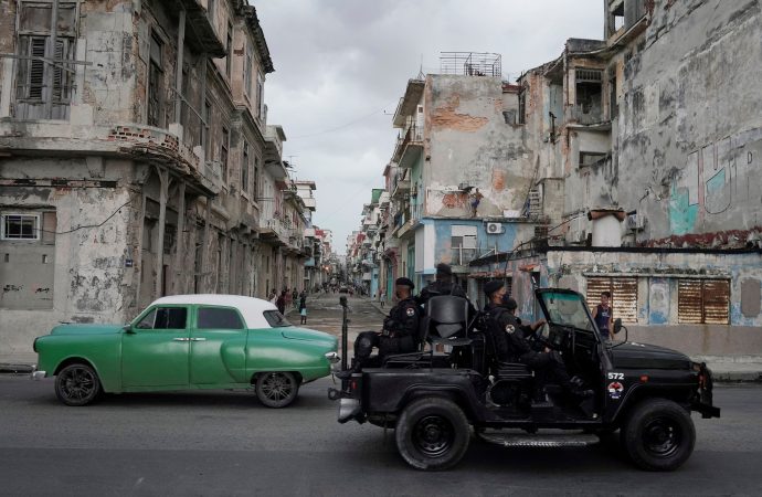 Một chiếc xe của lực lượng đặc biệt đi ngang qua một chiếc xe cổ ở trung tâm thành phố Havana ngày 13 tháng 7 năm 2021. (Nguồn: CNS photo / Alexandre Meneghini, Reuters)
