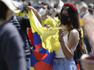 Một phụ nữ cầm cờ Colombia khi tham dự buổi cầu nguyện buổi trưa của Giáo hoàng Francis Angelus tại Quảng trường Thánh Peter ở Vatican, Chủ nhật, ngày 9 tháng 5 năm 2021 (Ảnh: Gregorio Borgia / AP)