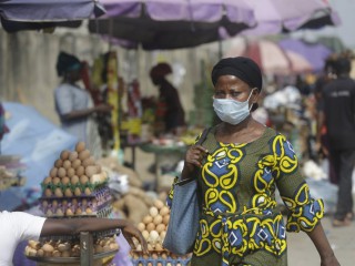 Một phụ nữ đeo khẩu trang để bảo vệ chống lại coronavirus, đi bộ trên đường phố, ở Lagos, Nigeria, Thứ Năm, ngày 31 tháng 12 năm 2020 (Ảnh: Sunday Alamba / AP)