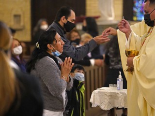 Một phụ nữ rước lễ trong Thánh lễ tưởng nhớ Cha Jorge Ortiz-Garay tại nhà thờ St. Brigid ở Brooklyn, New York, ngày 27 tháng 3, trong ngày kỷ niệm đầu tiên linh mục qua đời vì COVID-19. Ortiz-Garay, người từng là mục sư của St. Brigid, được công nhận là linh mục Công giáo đầu tiên ở Hoa Kỳ không chống lại được coronavirus (Ảnh: CNS / Gregory A. Shemitz)