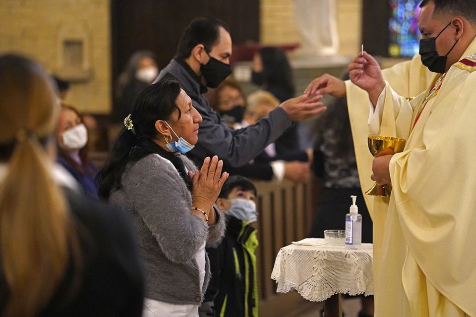 Một phụ nữ rước lễ trong Thánh lễ tưởng nhớ Cha Jorge Ortiz-Garay tại nhà thờ St. Brigid ở Brooklyn, New York, ngày 27 tháng 3, trong ngày kỷ niệm đầu tiên linh mục qua đời vì COVID-19. Ortiz-Garay, người từng là mục sư của St. Brigid, được công nhận là linh mục Công giáo đầu tiên ở Hoa Kỳ không chống lại được coronavirus (Ảnh: CNS / Gregory A. Shemitz)