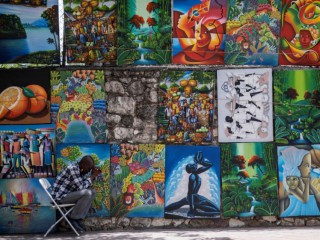 Một người bán hàng nghệ thuật đường phố ở Port-au-Prince, Haiti, cầu nguyện khoảng một tuần sau khi Tổng thống Haiti Jovenel Moïse bị ám sát vào ngày 7 tháng 7. Các cơ quan Công giáo phải đối mặt với những thách thức to lớn trong việc hỗ trợ người Haiti sống trong bối cảnh nghèo đói và bất ổn xã hội và chính trị. (CNS / Reuters / Ricardo Arduengo)