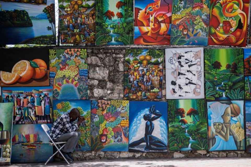 Một người bán hàng nghệ thuật đường phố ở Port-au-Prince, Haiti, cầu nguyện khoảng một tuần sau khi Tổng thống Haiti Jovenel Moïse bị ám sát vào ngày 7 tháng 7. Các cơ quan Công giáo phải đối mặt với những thách thức to lớn trong việc hỗ trợ người Haiti sống trong bối cảnh nghèo đói và bất ổn xã hội và chính trị. (CNS / Reuters / Ricardo Arduengo)