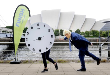 Một người mặc trang phục như Thủ tướng Anh Boris Johnson và một người mặc trang phục với chiếc đồng hồ nhằm thu hút sự chú ý về tính cấp bách của cuộc khủng hoảng khí hậu trong sáng kiến "Cuộc chạy đua với thời gian" tại Glasgow, ngày 16 tháng 8 năm 2021 (Ảnh: Colin Hattersley Photography/ SCIAF)