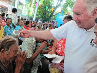 Cha Joseph Maier chúc phúc cho một người già ở khu ổ chuột trong lễ hội Năm mới của Thái Lan tại Trung tâm Lòng thương xót của ông ở Klong Toey, Bangkok. (Ảnh: Tibor Krausz)