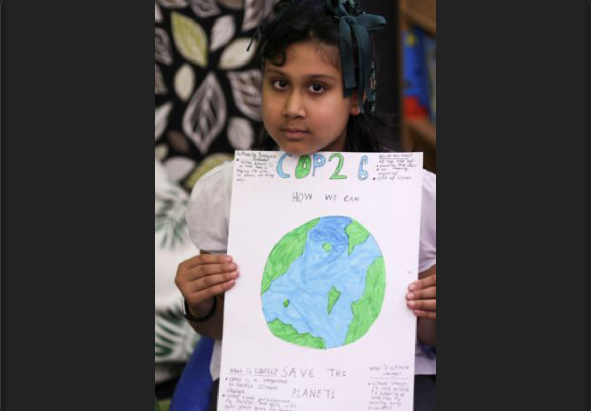 Một học sinh cầm một tấm áp phích tại trường tiểu học St. Conval trong khi tìm hiểu về vấn đề biến đổi khí hậu trước thềm Hội nghị về biến đổi khí hậu của Liên hợp quốc lần thứ 26 tại Glasgow, Scotland, ngày 19 tháng 190 năm 20121 (Ảnh: CNS/ Russell Cheyne/ Reuters)