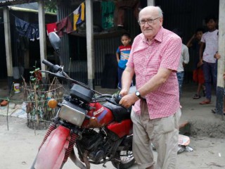 Cha Carlo Buzzi với chiếc xe máy của mình ở Belkuchi thuộc quận Sirajganj, miền bắc Bangladesh, nơi ông đã phục vụ những người Công giáo dân tộc nhập cư trong 24 năm (Ảnh: Stephan Uttom / UCA News)