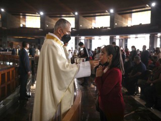 Một linh mục rước lễ trong Thánh lễ khai mạc Đại hội đồng Giáo hội thứ sáu của Châu Mỹ Latinh và Caribê tại Vương cung thánh đường Đức Mẹ Guadalupe ở Thành phố Mexico ngày 21 tháng 11 năm 2021. (Nguồn: Emilio Espejel / CNS)