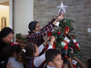 Một giáo viên trang trí cây thông Noel với các học sinh tại trường Rosary Sisters 'ở thành phố Gaza ngày 24 tháng 11 năm 2021. Sami El-Yousef, Giám đốc điều hành của Tòa Thượng phụ Latinh, người vừa tháp tùng Đức Tổng giám mục Pierbattista Pizzaballa trong chuyến thăm Giáng sinh hàng năm với cộng đồng Công giáo Gaza, cho biết mọi người trong cộng đồng tràn đầy hy vọng và khả năng phục hồi trong năm nay. (Tín dụng: Mohammed Salem / Reuters qua CNS)