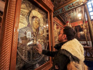 Milad Ayyad, một Kitô hữu Chính thống giáo Hy Lạp gốc Palestine từ Gaza, chạm vào biểu tượng Đức Trinh Nữ và Hài Nhi để được ban phước tại Vương cung thánh đường Hy Lạp ở Nhà thờ Chúa Giáng sinh, nơi truyền thống của Chúa Kitô, trong kinh thánh thành phố Bethlehem ở phía Tây bị chiếm đóng Ngân hàng vào ngày 26 tháng 12 năm 2021 (Ảnh: AFP)