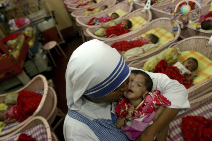 Ảnh chụp ngày 21 tháng 8 năm 2007, một nữ tu Thừa sai Bác ái của Mẹ Teresa hôn một trẻ sơ sinh tật nguyền tại Shishu Bhavan, một ngôi nhà dành cho trẻ em mồ côi, ở Kolkata, Ấn Độ. (Nguồn: Sucheta Das / AP.)
