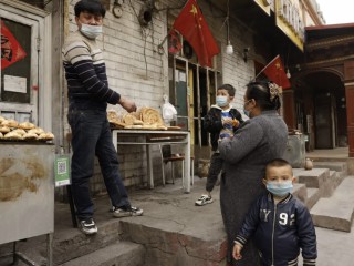 Người dân địa phương mua bánh mì từ một người bán hàng rong ở quận Shule ở khu tự trị Duy Ngô Nhĩ Tân Cương phía tây Trung Quốc, thứ Bảy, ngày 20 tháng 3 năm 2021 (Ảnh: Ng Han Guan / AP)