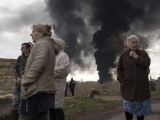 Người dân đứng trong sân chứng kiến những cột khói bốc lên nghi ngút sau vụ pháo kích ở Odessa, Ukraine, Chúa nhật, ngày 3 tháng 4 năm 2022 (Ảnh: Petros Giannakouris / AP)