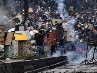 Những người biểu tình đụng độ với cảnh sát chống bạo động, gần công viên El Ejido, ở Quito, vào ngày 24 tháng 6 năm 2022, trong khuôn khổ các cuộc biểu tình do người bản xứ lãnh đạo chống chính phủ.  Chính phủ Ecuador và những người biểu tình bản địa đã cáo buộc lẫn nhau về thái độ không khoan nhượng khi hàng nghìn người tụ tập trong ngày thứ 12 của cuộc biểu tình về giá nhiên liệu đã cướp đi sinh mạng của 6 người và hàng chục người bị thương. Sau ngày bạo lực nhất của chiến dịch cho đến nay - với việc cảnh sát bắn hơi cay để giải tán hàng nghìn người đang xông vào Quốc hội - chính phủ cáo buộc những người biểu tình trốn tránh một kết quả hòa bình (Ảnh: Martin Bernetti / AFP qua Getty Images)