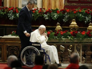Đức Thánh Cha Phanxicô được quản gia Sandro Mariotti đẩy trên xe lăn sau khi chia sẻ bài giảng trong Thánh lễ Chúa Thánh Thần Hiện xuống tại Vương Cung Thánh Đường Thánh Phêrô tại Vatican ngày 5 tháng 6 năm 2022 (Ảnh: CNS / Paul Haring)