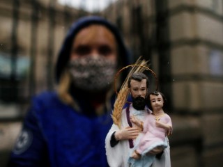 Một người phụ nữ cầm bức tượng mô tả Thánh Cajetan, Quan Thầy của những người lao động, vào dịp lễ kính thánh nhân vào ngày 7 tháng 8 năm 2020, ở Buenos Aires, Argentina (Ảnh: Agustin Marcarian / Reuters qua CNS)